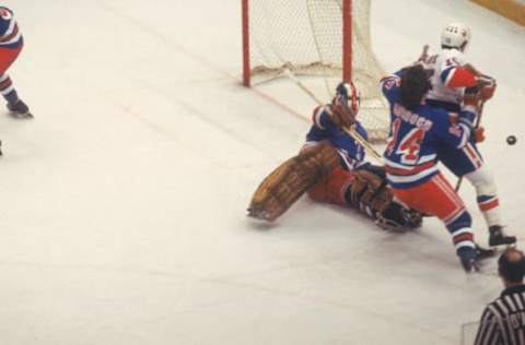 Canadian hockey player John Davidson, goalkeeper for the New York Rangers, on the ice as he and teammate Don Murdoch (# 14) tangle with Billy Harris of the New York Islanders during a playoff game at Nassau Coliseum, Uniondale, New York, 1979. (Photo by Melchior DiGiacomo/Getty Images)