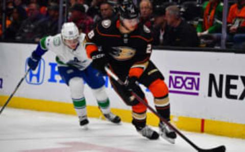 Mar 19, 2023; Anaheim, California, USA; Anaheim Ducks defenseman Nathan Beaulieu (28) moves the puck against Vancouver Canucks right wing Vasily Podkolzin (92) during the third period at Honda Center. Mandatory Credit: Gary A. Vasquez-USA TODAY Sports