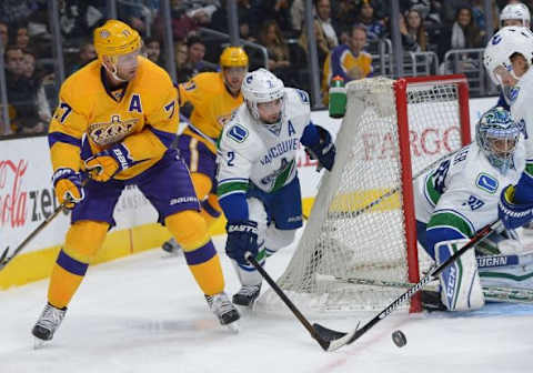 Mar 7, 2016; Los Angeles, CA, USA; Los Angeles Kings center Jeff Carter (77) sends the puck to the net as Vancouver Canucks defenseman Dan Hamhuis (2) and goalie Ryan Miller (30) defend in the second period of the game at Staples Center. Mandatory Credit: Jayne Kamin-Oncea-USA TODAY Sports