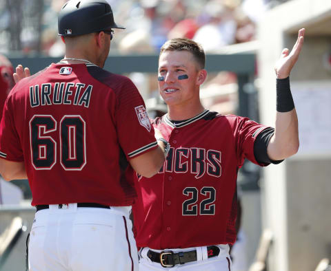 Arizona Diamondbacks first baseman Jake Lamb (22) talks with coach Luis Urueta (60) during a spring training game against the Milwaukee Brewers at Salt River Fields at Talking Stick March 24, 2019.Brewers Vs Diamondbacks