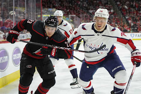 RALEIGH, NC – APRIL 18: Carolina Hurricanes left wing Brock McGinn (23) and Washington Capitals defenseman John Carlson (74) chase a puck along the boards during a game between the Carolina Hurricanes and the Washington Capitals on April 18, 2019, at the PNC Arena in Raleigh, NC. (Photo by Greg Thompson/Icon Sportswire via Getty Images)