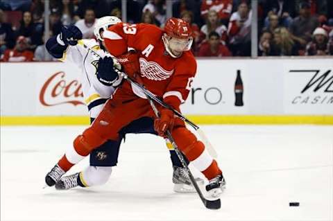 April 25, 2013; Detroit, MI, USA; Detroit Red Wings center Pavel Datsyuk (13) and Nashville Predators left wing Richard Clune (16) battle for the puck in the second period at Joe Louis Arena. Mandatory Credit: Rick Osentoski-USA TODAY Sports