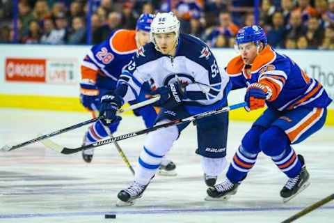 Feb 13, 2016; Edmonton, Alberta, CAN; Winnipeg Jets center Mark Scheifele (55) and Edmonton Oilers right wing Iiro Pakarinen (26) battle for the puck during the first period at Rexall Place. Mandatory Credit: Sergei Belski-USA TODAY Sports