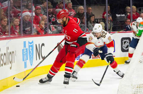 Dec 21, 2019; Raleigh, North Carolina, USA; Carolina Hurricanes center Jordan Staal (11) skates with the puck against Florida Panthers defenseman MacKenzie Weegar (52) during the first period at PNC Arena. Mandatory Credit: James Guillory-USA TODAY Sports