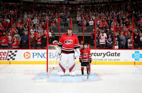 RALEIGH, NC – FEBRUARY 16: Cam Ward #30 of the Carolina Hurricanes reflects during the National Anthem as he shares the crease with his son Nolan Ward who is named starter of the game prior to an NHL game against the New York Islanders on February 16, 2018 at PNC Arena in Raleigh, North Carolina. (Photo by Gregg Forwerck/NHLI via Getty Images)