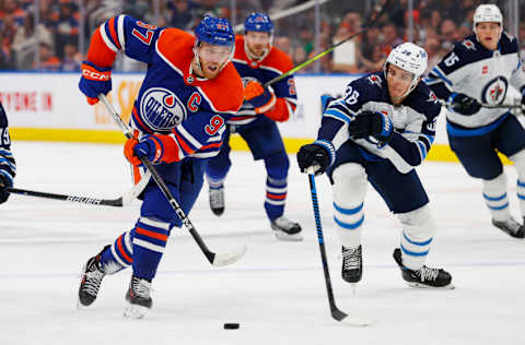 Oct 21, 2023; Edmonton, Alberta, CAN; Edmonton Oilers forward Connor McDavid (97) carries the puck around Winnipeg Jets forward Morgan Barron (36) during the third period at Rogers Place. Mandatory Credit: Perry Nelson-USA TODAY Sports