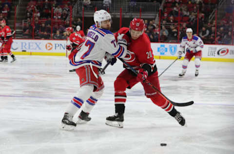 RALEIGH, NC – FEBRUARY 19: Carolina Hurricanes center Sebastian Aho (20) and New York Rangers defenseman Tony DeAngelo (77) fight for the puck during the 1st period of the Carolina Hurricanes game versus the New York Rangers on February 19th, 2019 at PNC Arena in Raleigh, NC. (Photo by Jaylynn Nash/Icon Sportswire via Getty Images)