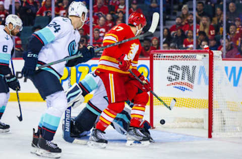 Nov 1, 2022; Calgary, Alberta, CAN; Calgary Flames left wing Milan Lucic (17) reaches for the puck against Seattle Kraken goaltender Joey Daccord (35) during the third period at Scotiabank Saddledome. Mandatory Credit: Sergei Belski-USA TODAY Sports