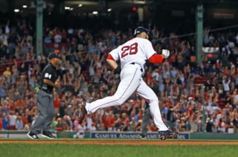 BOSTON – JULY 9: Boston Red Sox player J.D. Martinez (28) pumps his fist as his bottom of the eighth inning three-run home run cleared the wall. Teammates Mookie Betts (background far left) and Andrew Benintendi (background far right) round the bases ahead of him. The Boston Red Sox host the Texas Rangers in a regular season MLB baseball game at Fenway Park in Boston on July 9, 2018. (Photo by Jim Davis/The Boston Globe via Getty Images)