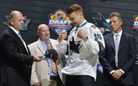 Jun 26, 2015; Sunrise, FL, USA; Timo Meier puts on a team jersey after being selected as the number nine overall pick to the San Jose Sharks in the first round of the 2015 NHL Draft at BB&T Center. Mandatory Credit: Steve Mitchell-USA TODAY Sports