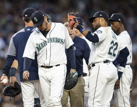 SEATTLE, WA – SEPTEMBER 8: Starting pitcher Felix Hernandez #34 of the Seattle Mariners gets a pat on the back from first baseman Robinson Cano #22 of the Seattle Mariners as he leaves the game after a meeting at the mound that included Seattle Mariners training staff during the fifth inning of a game against the New York Yankees at Safeco Field on September 8, 2018 in Seattle, Washington. (Photo by Stephen Brashear/Getty Images)