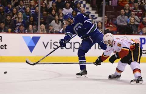 Feb 6, 2016; Vancouver, British Columbia, CAN; Vancouver Canucks forward Sven Baertschi (47) shoots the puck as Calgary Flames defenseman Mark Giordano (5) reaches across during the first period at Rogers Arena. Mandatory Credit: Anne-Marie Sorvin-USA TODAY Sports