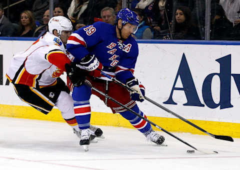 Dec 15, 2013; New York, NY, USA; New York Rangers center Brad Richards (19) fights for control of the puck with Calgary Flames defenseman Ladislav Smid (3) during the second period at Madison Square Garden. Mandatory Credit: Adam Hunger-USA TODAY Sports