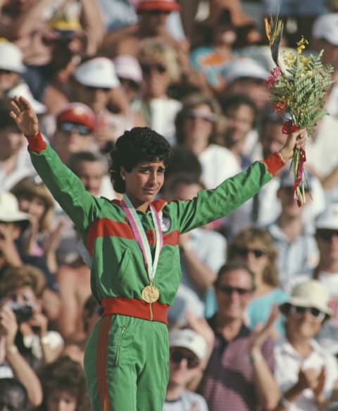 Nawal El Moutawakel standing on the Olympic podium.