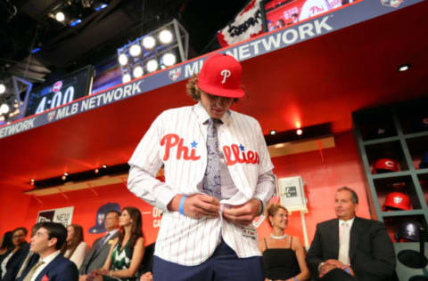 SECAUCUS, NJ – JUNE : Alec Bohm puts on the hat and jersey of the Philadelphia Phillies after being selected third overall by the Phillies during the 2018 Major League Baseball Draft at Studio 42 at the MLB Network on Monday, June 4, 2018 in Secaucus, New Jersey. (Photo by Alex Trautwig/MLB Photos via Getty Images)