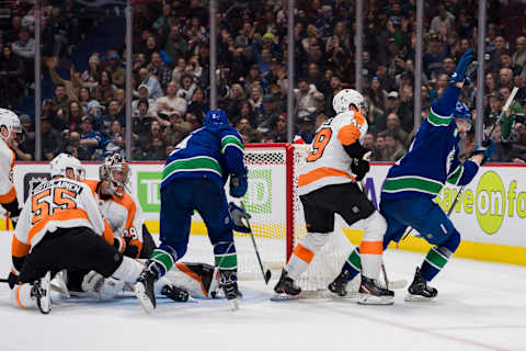 Feb 18, 2023; Vancouver, British Columbia, CAN; Philadelphia Flyers defenseman Rasmus Ristolainen (55) and goalie Carter Hart (79) and forward Noah Cates (49) and Vancouver Canucks forward J.T. Miller (9) watch as forward Phillip Di Giuseppe (34) celebrates his goal in the third period at Rogers Arena. Canucks won 6-2. Mandatory Credit: Bob Frid-USA TODAY Sports