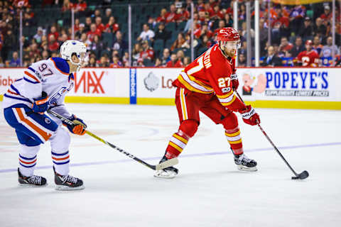 Jan 21, 2017; Calgary, Alberta, CAN; Calgary Flames defenseman Dougie Hamilton (27) controls the puck in front of Edmonton Oilers center Connor McDavid (97) during the third period at Scotiabank Saddledome. Edmonton won 7-3. Mandatory Credit: Sergei Belski-USA TODAY Sports