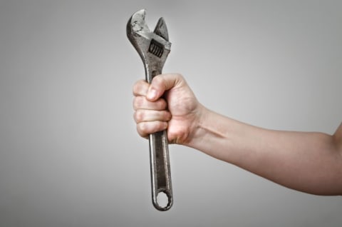 Person holding a metal wrench