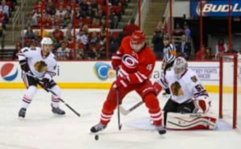 October 15, 2013; Raleigh, NC, USA; Carolina Hurricanes left wing Tuomo Ruutu (15) goes for the rebound in front of the Chicago Blackhawks goalie Corey Crawford (50) during the 2nd period at PNC Center. Mandatory Credit: James Guillory-USA TODAY Sports