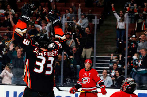 ANAHEIM, CA – DECEMBER 7: Jakob Silfverberg #33 of the Anaheim Ducks celebrates after scoring his 100th NHL goal against Justin Williams #14 and Petr Mrazek #34 of the Carolina Hurricanes during the game on December 7, 2018, at Honda Center in Anaheim, California. (Photo by Debora Robinson/NHLI via Getty Images)