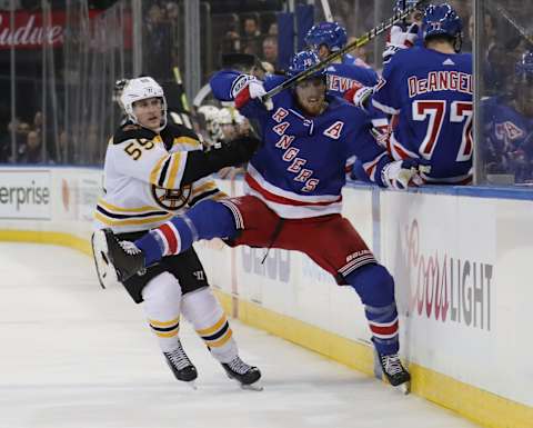 NEW YORK, NEW YORK – FEBRUARY 06: Noel Acciari #55 of the Boston Bruins checks Marc Staal #18 of the New York Rangers into the bench during the third period at Madison Square Garden on February 06, 2019 in New York City. The Rangers defeated the Bruins 4-3 in the shoot-out.(Photo by Bruce Bennett/Getty Images)