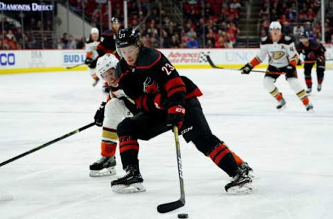 RALEIGH, NC – JANUARY 17: Brock McGinn #23 of the Carolina Hurricanes controls the puck away from the defense of Hampus Lindholm #47 of the Anaheim Ducks during an NHL game on January 17, 2020 at PNC Arena in Raleigh, North Carolina. (Photo by Gregg Forwerck/NHLI via Getty Images)