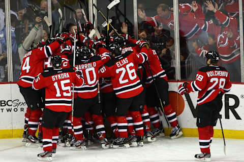 New Jersey Devils surround Travis Zajac #19 (Photo by Chris Chambers/Getty Images)