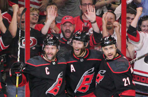 RALEIGH, NC – MAY 03: Carolina Hurricanes center Jordan Staal (11) and Carolina Hurricanes right wing Nino Niederreiter (21) congratulate Carolina Hurricanes right wing Justin Williams (14) after scoring his 100th playoff point during a game between the Carolina Hurricanes and the New York Islanders on March 3, 2019 at the PNC Arena in Raleigh, NC. (Photo by Greg Thompson/Icon Sportswire via Getty Images)