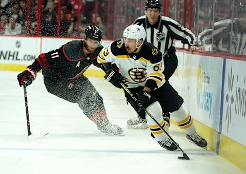 RALEIGH, NC – MAY 14: Brad Marchand #63 of the Boston Bruins controls the puck away from Jordan Staal #11 of the Carolina Hurricanes in Game Three of the Eastern Conference Third Round during the 2019 NHL Stanley Cup Playoffs on May 14, 2019 at PNC Arena in Raleigh, North Carolina. (Photo by Gregg Forwerck/NHLI via Getty Images)