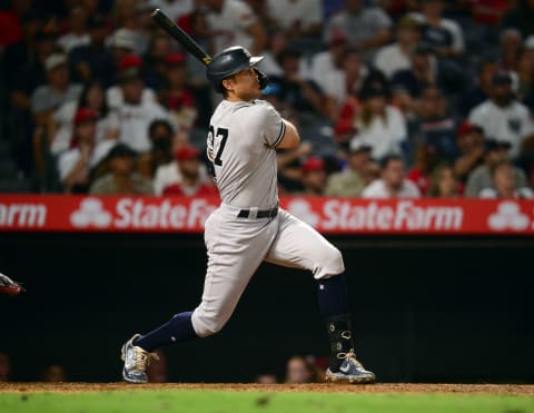 Aug 30, 2021; Anaheim, California, USA; New York Yankees designated hitter Giancarlo Stanton (27) hits a two run home run against the Los Angeles Angels during the seventh inning at Angel Stadium. Mandatory Credit: Gary A. Vasquez-USA TODAY Sports