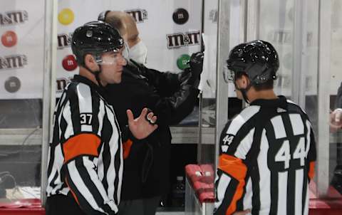 Referees Kyle Rehman #37 and Kendrick Nicholson #44 go over the rosters prior to the game between the New York Islanders and the New Jersey Devils. (Photo by Bruce Bennett/Getty Images)