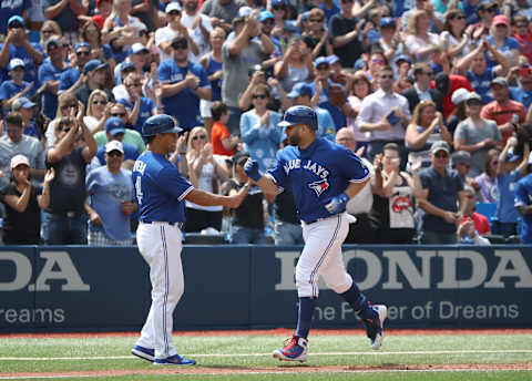 TORONTO, ON – AUGUST 22: Kendrys Moralles #8 of the Toronto Blue Jays is congratulated by third base coach Luis Rivera #4 after hitting a solo home run in the seventh inning during MLB game action against the Baltimore Orioles at Rogers Centre on August 22, 2018 in Toronto, Canada. (Photo by Tom Szczerbowski/Getty Images)