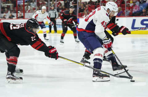 RALEIGH, NC – APRIL 18: Carolina Hurricanes defenseman Brett Pesce (22) pokes the puck away from Washington Capitals right wing Tom Wilson (43) during a game between the Carolina Hurricanes and the Washington Capitals on April 18, 2019, at the PNC Arena in Raleigh, NC. (Photo by Greg Thompson/Icon Sportswire via Getty Images)