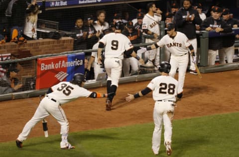 Oct 10, 2016; San Francisco, CA, USA; San Francisco Giants catcher Buster Posey (28) and first baseman Brandon Belt (9) celebrate scoring with shortstop Brandon Crawford (35) in the eighth inning against the Chicago Cubs during game three of the 2016 NLDS playoff baseball series at AT&T Park. Mandatory Credit: John Hefti-USA TODAY Sports