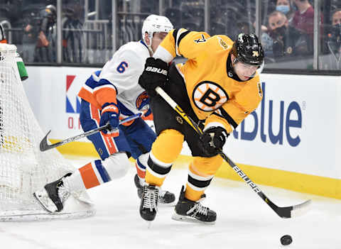 Apr 15, 2021; Boston, Massachusetts, USA; Boston Bruins left wing Jake DBrusk (74) tries to gain control of the puck in front of New York Islanders defenseman Ryan Pulock (6) during the second period at TD Garden. Mandatory Credit: Bob DeChiara-USA TODAY Sports