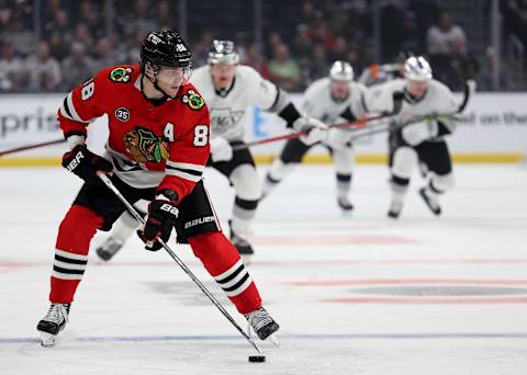 LOS ANGELES, CALIFORNIA – MARCH 24: Patrick Kane #88 of the Chicago Blackhawks skates away with the puck as he is chased by the Los Angeles Kings during the first period at Crypto.com Arena on March 24, 2022 in Los Angeles, California. (Photo by Harry How/Getty Images)