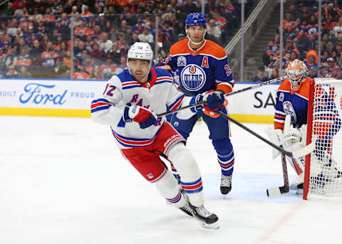 EDMONTON, CANADA – OCTOBER 26: Connor Mackey #12 of the New York Rangers pursues the puck, Darnell Nurse #25 of the Edmonton Oilers watches the play in the first period on October 26, 2023 at Rogers Place in Edmonton, Alberta, Canada. (Photo by Lawrence Scott/Getty Images)