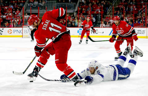 The Carolina Hurricanes’ Jordan Staal (11) steps on the puck as he drives past the fallen Dan Girardi of the Tampa Bay Lightning during the first period at PNC Arena in Raleigh, N.C., on Saturday, April 7, 2018. (Chris Seward/Raleigh News