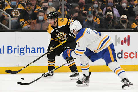 Jan 1, 2022; Boston, Massachusetts, USA; Boston Bruins defenseman Connor Clifton (75) skates with the puck against Buffalo Sabres defenseman Will Butcher (4) during the first period at TD Garden. Mandatory Credit: Brian Fluharty-USA TODAY Sports