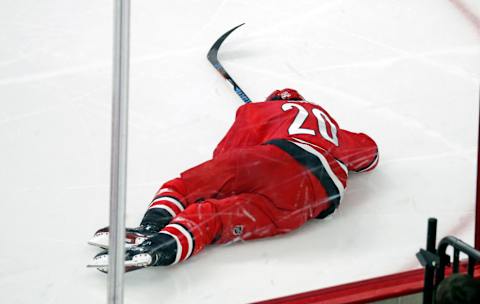 The Carolina Hurricanes’ Sebastian Aho (20) lies on the ice after he was hit by the Calgary Flames’ Mark Giordano (5) during the third period on Sunday, Jan. 14, 2018 at PNC Arena in Raleigh, N.C. Giordano was given a game misconduct penalty. Aho did not return to the game. The Flames beat the Canes, 4-1. (Chris Seward/Raleigh News