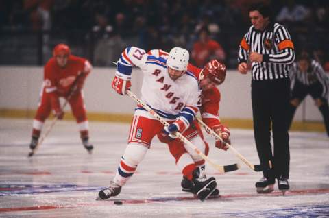 NEW YORK – 1982: New York Rangers’ center Mike Rogers #27 wins a faceoff against the Detroit Red Wings during a game at Madison Square Garden circa 1982 in New York, New York. (Photo by Focus on Sport/Getty Images)