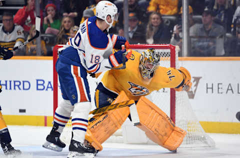 Dec 19, 2022; Nashville, Tennessee, USA; Nashville Predators goaltender Juuse Saros (74) is hit by Edmonton Oilers left wing Zach Hyman (18) in front of the net during the second period at Bridgestone Arena. Mandatory Credit: Christopher Hanewinckel-USA TODAY Sports