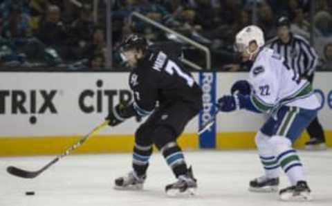 Mar 31, 2016; San Jose, CA, USA; San Jose Sharks defenseman Paul Martin (7) skates with the puck as Vancouver Canucks left wing Daniel Sedin (22) chases in the second period at SAP Center at San Jose. Mandatory Credit: Kenny Karst-USA TODAY Sports