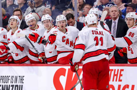 WINNIPEG, MB – DECEMBER 17: Jordan Staal #11 of the Carolina Hurricanes celebrates a third period goal against the Winnipeg Jets with teammates at the bench at the Bell MTS Place on December 17, 2019 in Winnipeg, Manitoba, Canada. (Photo by Darcy Finley/NHLI via Getty Images)