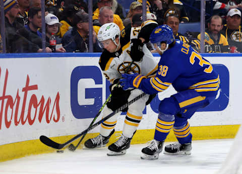 Mar 19, 2023; Buffalo, New York, USA; Boston Bruins defenseman Charlie McAvoy (73) and Buffalo Sabres defenseman Kale Clague (38) go after a loose puck during the third period at KeyBank Center. Mandatory Credit: Timothy T. Ludwig-USA TODAY Sports