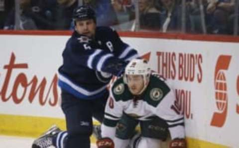 Apr 3, 2016; Winnipeg, Manitoba, CAN; Winnipeg Jets defenseman Mark Stuart (5) battles Minnesota Wild center Jordan Schroeder (10) along the boards during the first period at MTS Centre. Mandatory Credit: Bruce Fedyck-USA TODAY Sports