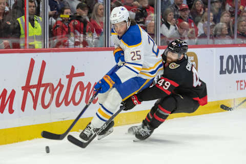 Oct 24, 2023; Ottawa, Ontario, CAN; Buffalo Sabres defenseman Owen Power (25) battles with Ottawa Senators center Rourke Chartier (49) for control of the puck in the first period at the Canadian Tire Centre. Mandatory Credit: Marc DesRosiers-USA TODAY Sports