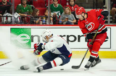 RALEIGH, NC – SEPTEMBER 29: Carolina Hurricanes defenseman Brett Pesce (22) toe drags the puck around Washington Capitals defenseman Dmitry Orlov (9) causing him to fall to the ice during an NHL Preseason game between the Washington Capitals and the Carolina Hurricanes on September 29, 2019 at the PNC Arena in Raleigh, NC. (Photo by Greg Thompson/Icon Sportswire via Getty Images)