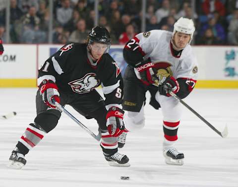 BUFFALO, NY – NOVEMBER 2: Brian Campbell #51 of the Buffalo Sabres tries to control the puck ahead of Peter Schaefer #27 of the Ottawa Senators on November 2, 2005 at HSBC Arena in Buffalo, New York. The Senators defeated the Sabres 10-4. (Photo by Rick Stewart/Getty Images)