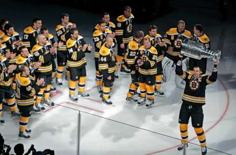 BOSTON – OCTOBER 6: The Bruins Zdeno Chara hoist the Stanley Cup as teammates applaud. The Boston Bruins opened up the 2011-12 NHL regular season at the TD Garden vs. the Philadelphia Flyers. Before the game, they raised the championship banner in recognition of their Stanley Cup Championship season of 2010-11. (Photo by Jim Davis/The Boston Globe via Getty Images)